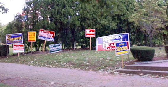 Vorgarten mit Wahlschildern, auf denen nur Namen stehen