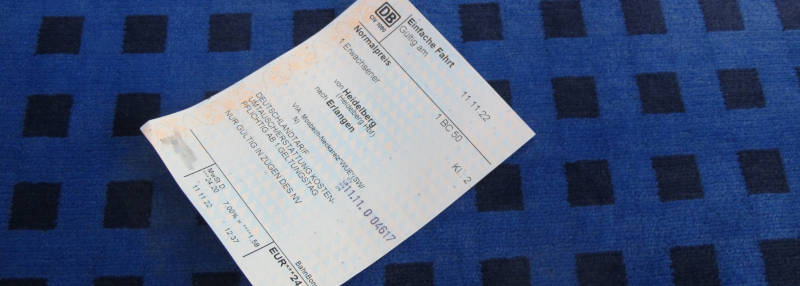 Eine Papier-Fahrkarte auf dem Bezug von Nahverkehrssitzen in den Bahn