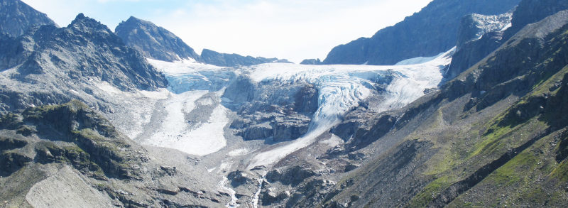 Foto einer Gletscherzunge zwischen Bergen