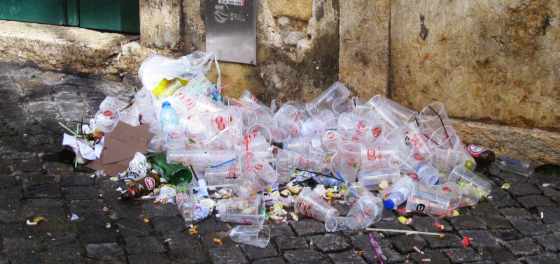 Ein großer Haufen Plastikbecher auf einer gepflasterten Straße