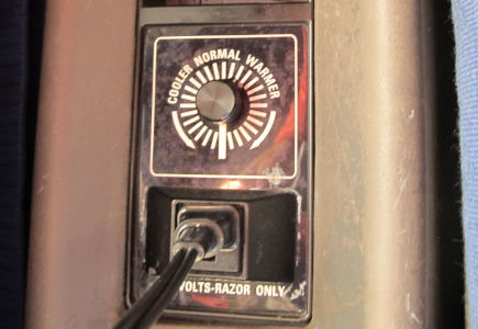 A round temperature selector (cooler/normal/warmer) above a U.S. three-prong plug marked “120 volts – razor only”