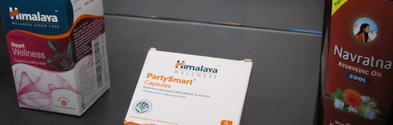 Drei Medikamentengebinde, das mittlere eine Pappschachtel mit der Aufschrft "PartySmart Capsules/Relieves unpleasant after-effects of alcohol" der Firma Himalaya Wellness