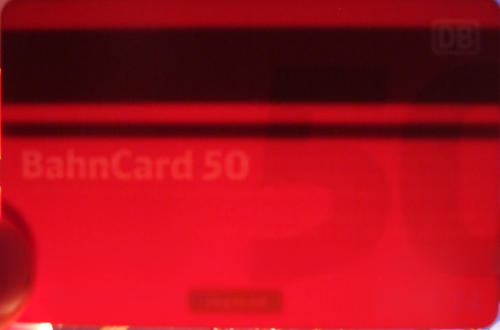Eine rote Scheckkarte im Gegenlicht.  Ein Magnetstreifen ist sichtbar, ein Schriftzug „Bahncard 50“, aber nichts, was elektronisch aussieht.