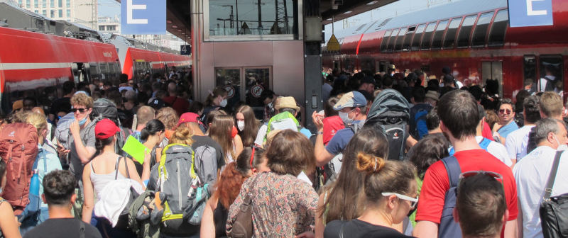 A shocking crowd of people squeezed onto a platform.  At least it's visibly warm.