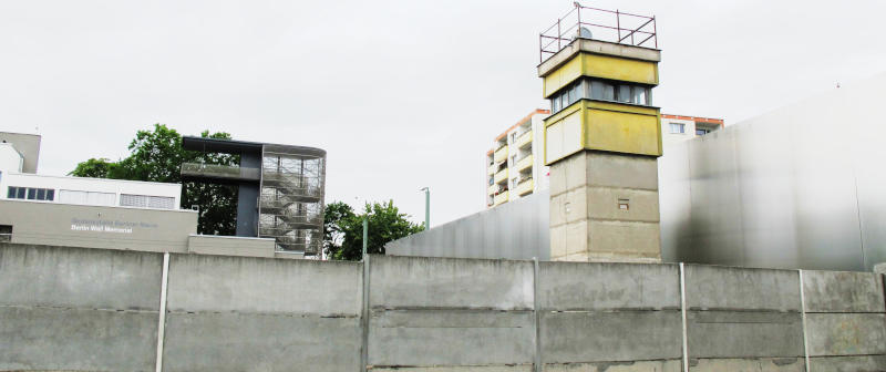 Foto: Betonmauer und Wachturm, rekonstruiert an der Mauer-Gedenkstätte in der Bornholmer Straße in Berlin, gesehen von der alten Ostseite.