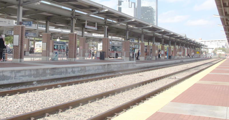 Tracks, platforms with roofs above them, open sky between the roofs.