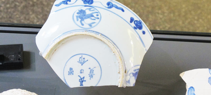 Eine Porzellanscherbe mit chinesischen Schriftzeichen