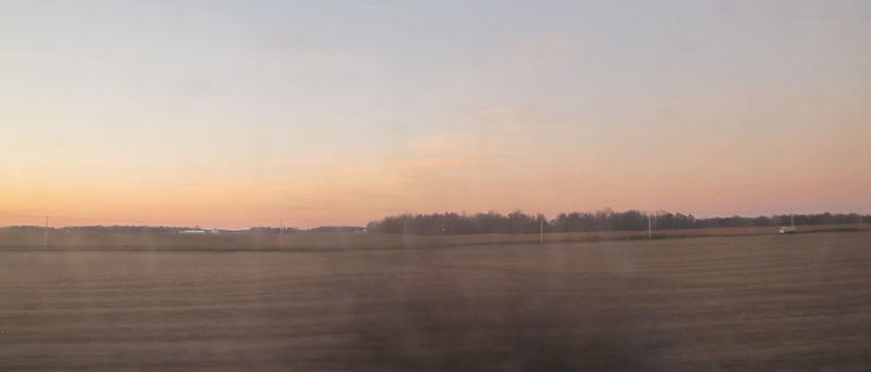 A huge field with reaching to a red horizon, the sky turning into blue towards higher elevations