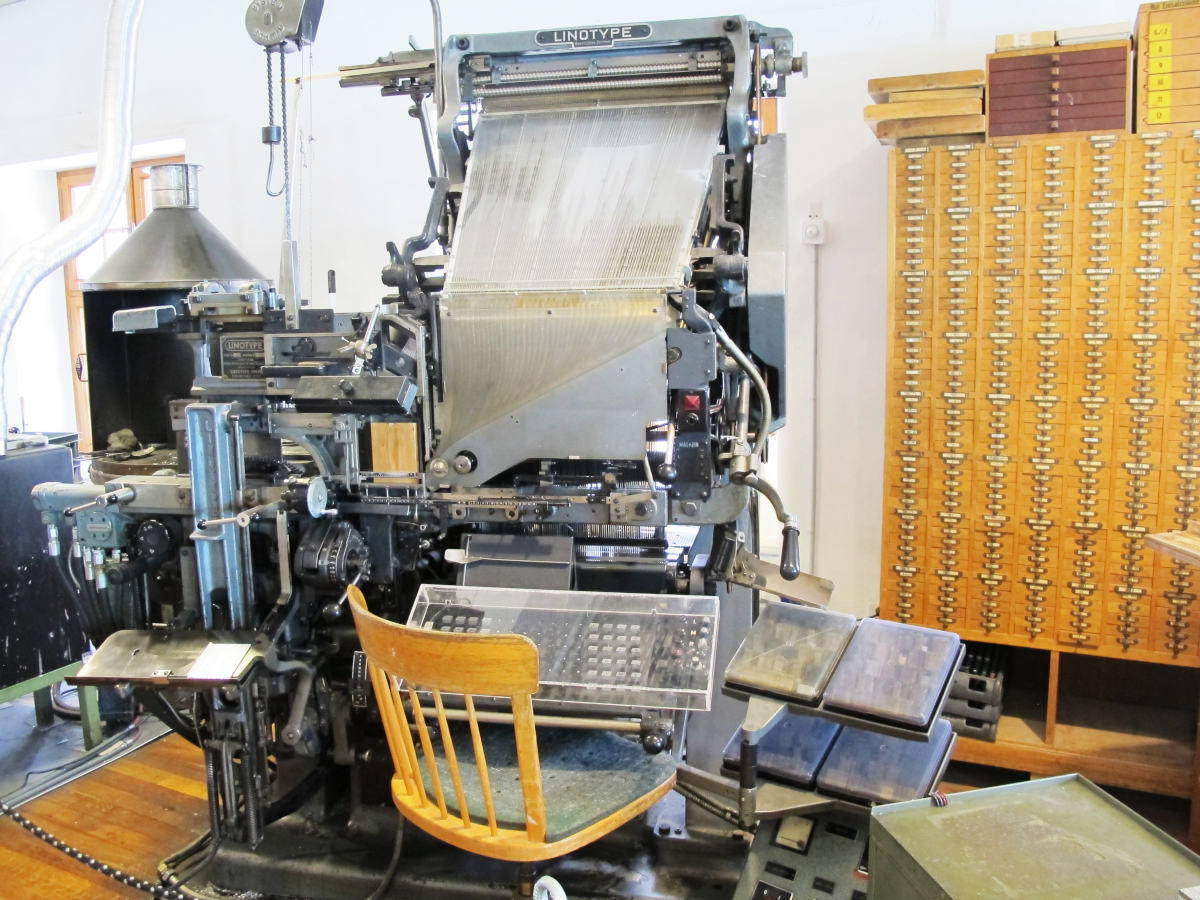 Ein komplizierter Mechanismus mit Tastatur und einem stolzen Typenschild „Linotype“ am ca. zwei Meter hohen Gehäuse.