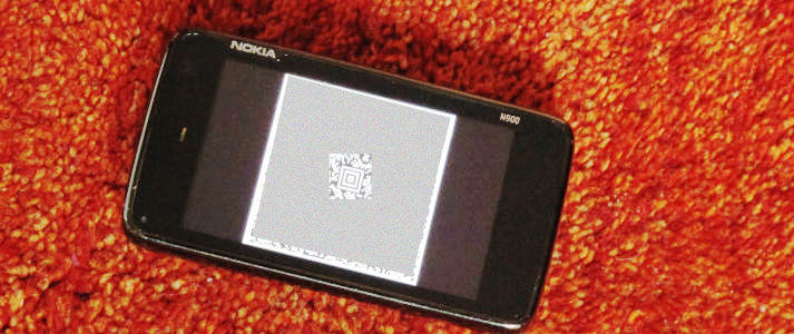 Foto eines altmodischen Telefons mit einem anonymisierten Barcode im Display