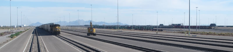 About half a dozen endless tracks with asphalt paving between them.  there on one track, there is a train with yelluw union pacific locomotives pulling it.