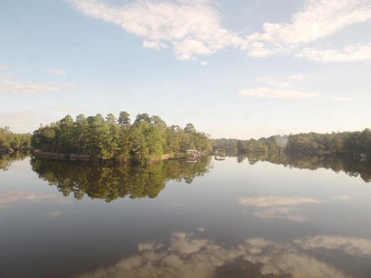 A lake with a bright reflection of a blue sky with a few clouds.