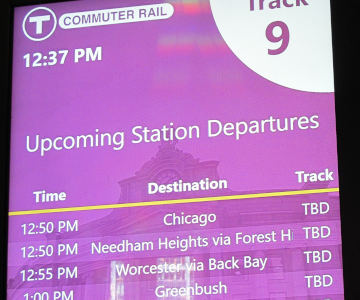 A screen showing departures to Chicago, Needham Heights, Worcester, track all TBD.  That's at 12:37, where the next trains depart 12:50.