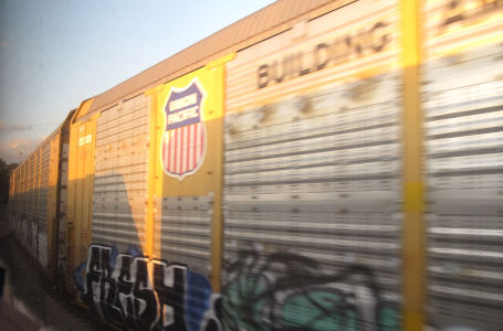 A few freight cars in a curve, one has a Union Pacific logo on it and a claim “Bulding A…”