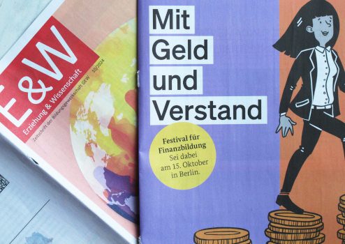 Anzeige über dem Titelblatt einer Zeitschrift: Eine Frau läuft über wachsende Münzstapel, groß „Mit Geld und Verstand“, eine URL mitgeldundverstand.de/festival, und die Logos von Finanz- und Wissenschaftsministerium.