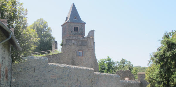 Eine offensichtlich modern restaurierte Burg mit einem behaubten Turm.