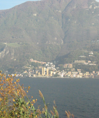 A lake with a rather sizeable mountain behind it.  At the foot of the mountain, a town with a large concrete block in the midst of the normal houses.