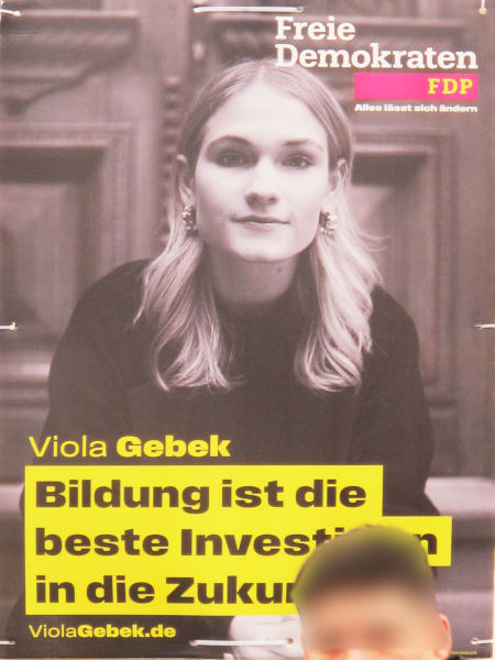 Plakat mit dem Portrait einer Frau vor einer Holzvertäfelung: Bildung ist die beste Investition in die Zukunft.