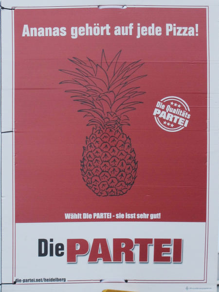 Schwarz auf rot eine gezeichnete Ananas, darüber in Weiß: Ananas gehört auf jede Pizza!