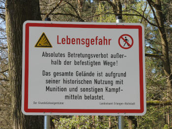 Ein rot umrandetes Schild vor Bäumen: „Lebensgefahr/Absolutes Betretungsverbot…“