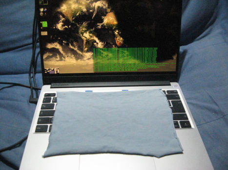 A notebook computer with a rectangular piece of cloth over the keyboard.