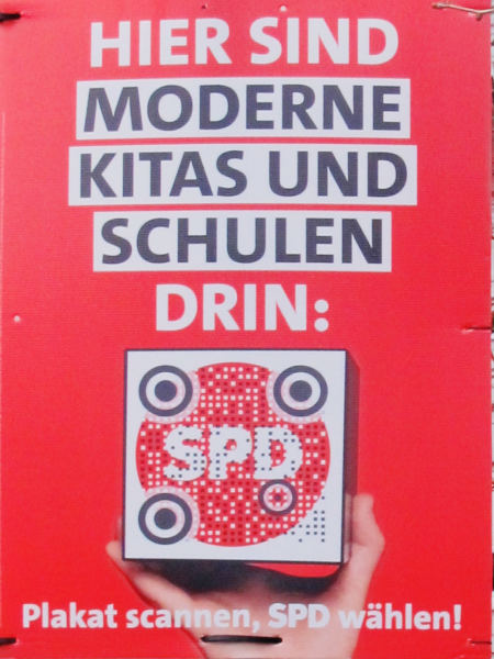 Weiß und schwarz auf rotem Grund "Hier sind moderne Kitas und Schulen drin"