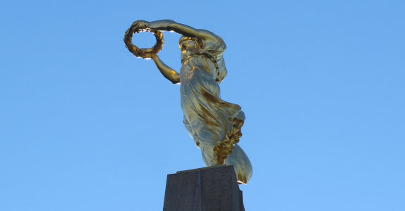 Vor blauem Himmel: eine goldene Frauengestalt